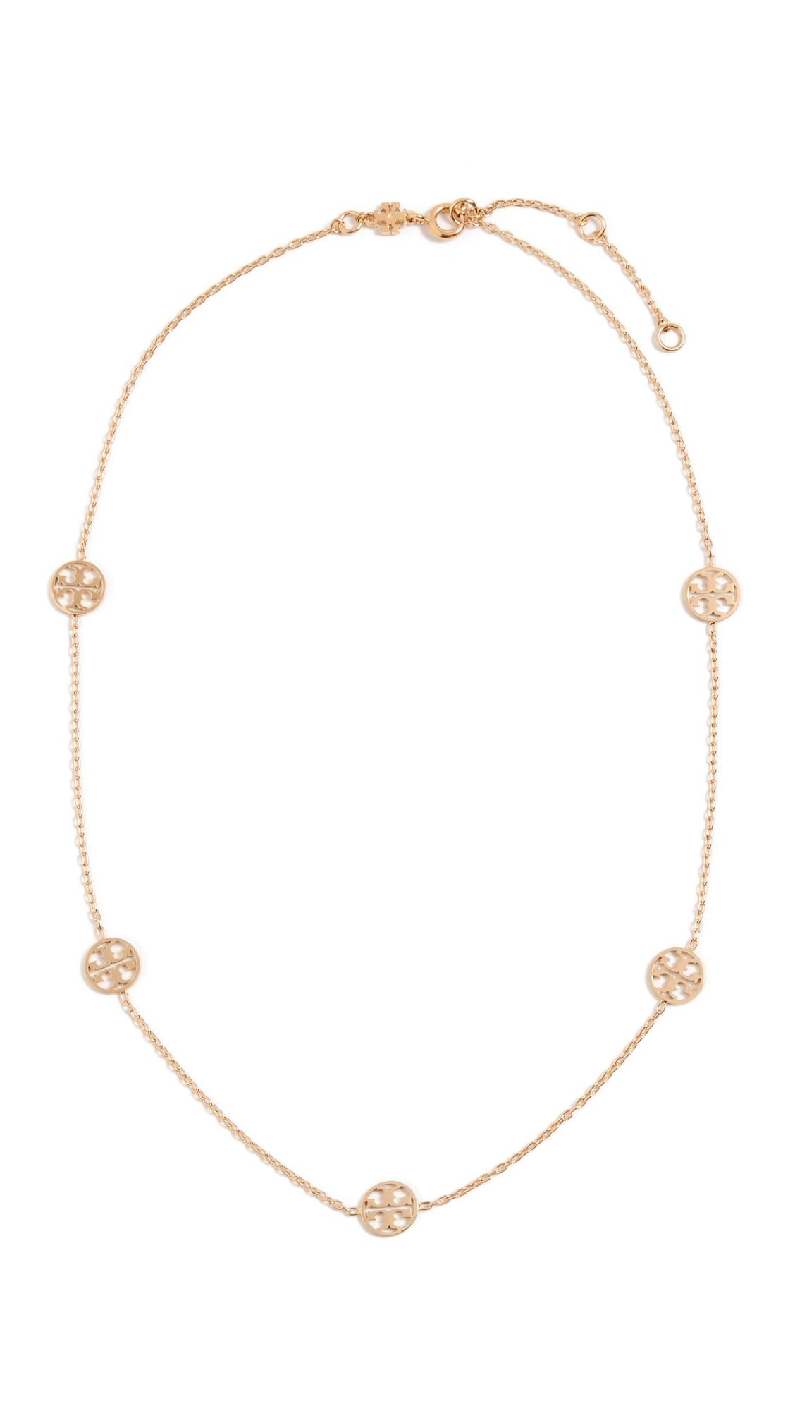 Gold necklace with five round logo pendants on a delicate chain