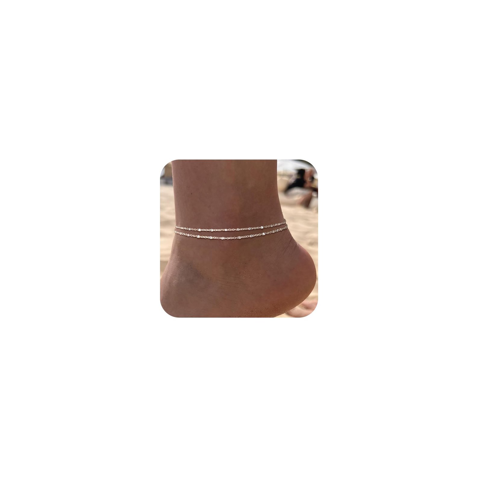 Ankle with two delicate silver anklets on a beach background