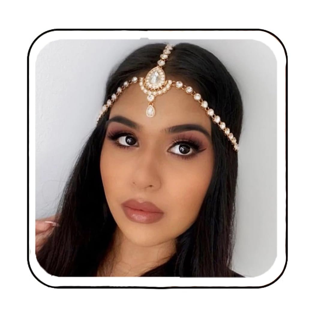 Woman wearing a jeweled headpiece, with dark hair and makeup, looking at the camera