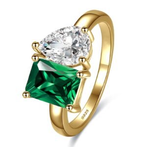 Gold ring with pear-shaped white gem and square green gem