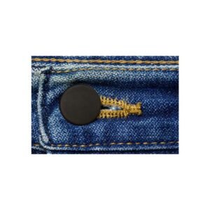 Close-up of a black button on blue denim jeans with yellow stitching