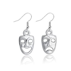 Silver earrings with comedy and tragedy masks, reflecting on white surface