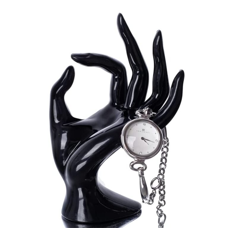 Black hand statue holding a silver pocket watch with chain