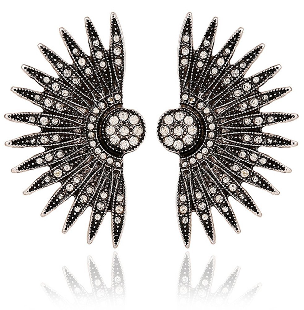 Pair of silver-toned, crystal-studded wing earrings on a white background