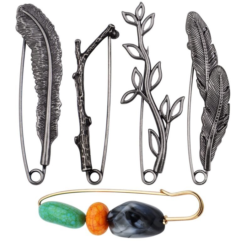 Four metal brooches with nature-inspired designs and one beaded safety pin
