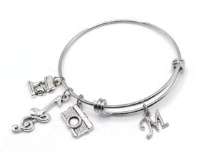 Silver charm bracelet with sewing machine, camera, music note, and letter "M" charms