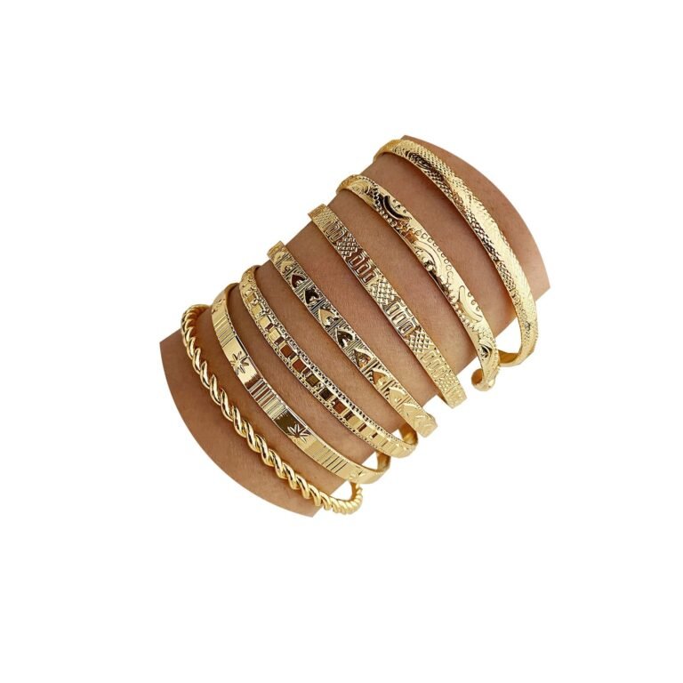 Gold bangles of various designs stacked on a person's arm